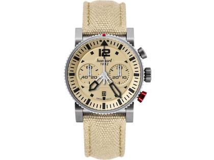 Hanhart PRIMUS Desert Pilot Chronograph Automatik Edelstahl 44mm beiges Zifferblatt beiges Textilband – Herrenuhren Chronograph aus Edelstahl. Das Gehäuse ist rund und silber. Das Textilarmband ist beige. Das Zifferblatt ist arabisch Index und beige.