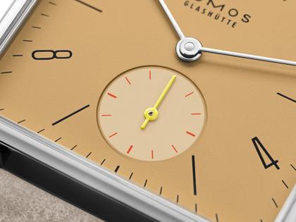 Nomos Glashütte Tetra Origins Ochra Handaufzug Edelstahl 29,5mm gelbes Zifferblatt graues Lederband Stahlboden – Damenuhren Uhr ohne Datum aus Edelstahl und Leder. Das Gehäuse ist quadratisch und silber. Das Lederarmband ist grau. Das Zifferblatt ist arabisch Index und gelb. – Ansicht 6