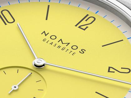 Nomos Glashütte Tangente 38 Datum "175 Years Watchmaking - Kanari" Handaufzug Edelstahl gelbes Zifferblatt graues Textilband Glasboden – Herrenuhren Uhr mit Datum aus Edelstahl. Das Gehäuse ist rund und silber. Das Textilarmband ist grau. Das Zifferblatt ist arabisch Index und gelb. – Ansicht 5