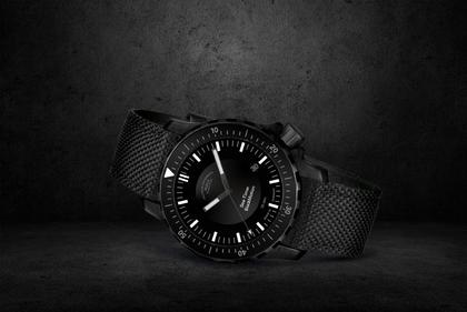 Mühle Glashütte Sea-Timer Blackmotion Automatik Edelstahl PVD-Schwarz 44mm schwarzes Zifferblatt schwarzes Textilband – Herrenuhren Uhr mit Datum aus Edelstahl, PVD beschichtet und Titancarbid beschichtet. Das Gehäuse ist rund und schwarz. Das Kautschuk / Kunststoff / Silikon Armband ist schwarz. Das Zifferblatt ist ein Index in schwarz. – Ansicht 2