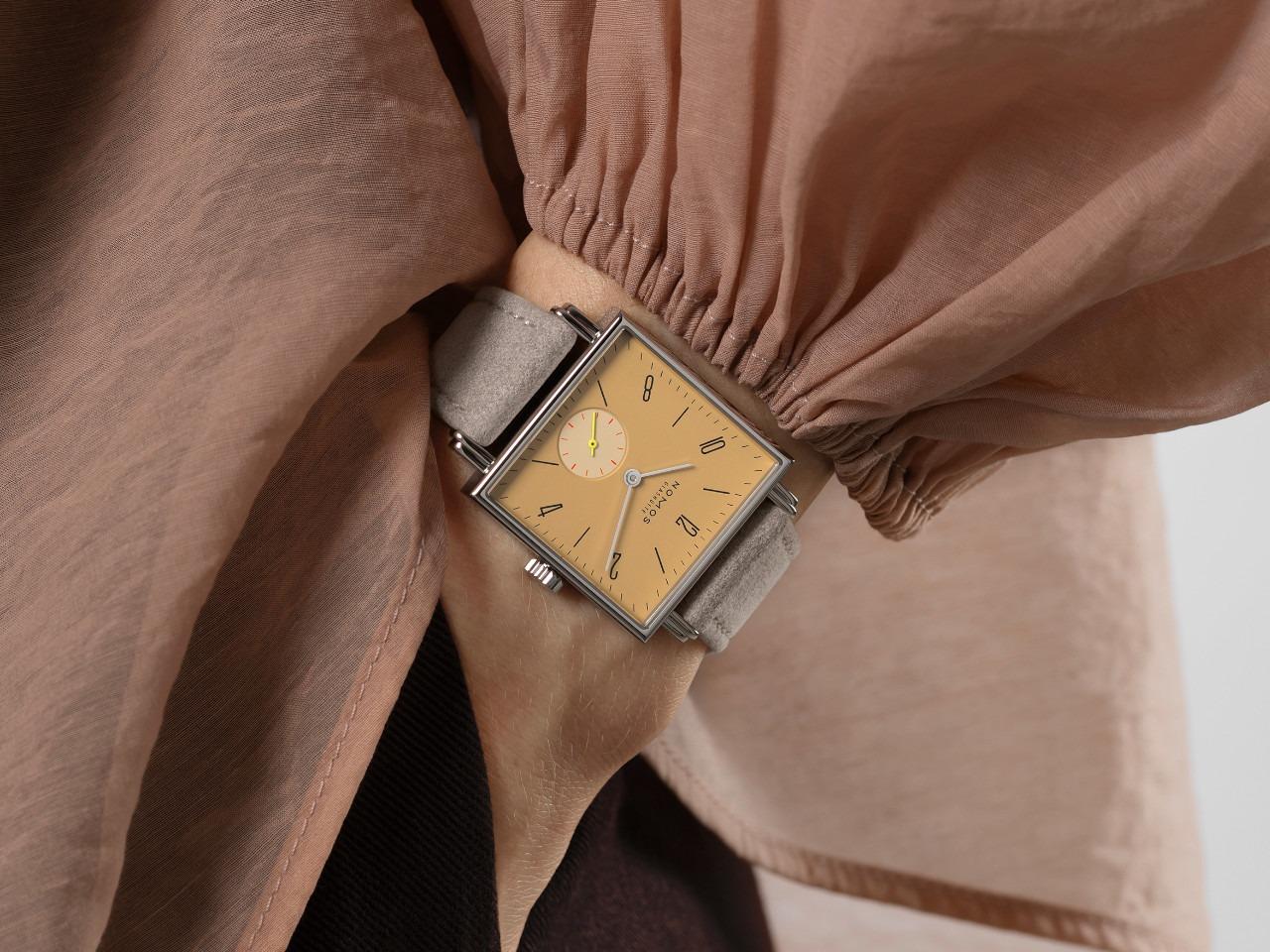 Nomos Glashütte Tetra Origins Ochra Handaufzug Edelstahl 29,5mm gelbes Zifferblatt graues Lederband Glasboden – Damenuhren Uhr ohne Datum aus Edelstahl und Leder. Das Gehäuse ist quadratisch und silber. Das Lederarmband ist grau. Das Zifferblatt ist arabisch Index und gelb. – Ansicht 12