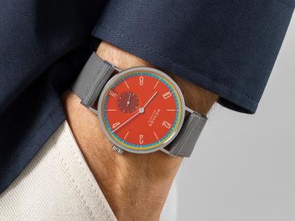 Nomos Glashütte Tangente 38 Datum "175 Years Watchmaking - Sportbunt" Handaufzug Edelstahl rotes Zifferblatt graues Textilband Glasboden – Herrenuhren Uhr mit Datum aus Edelstahl. Das Gehäuse ist rund und silber. Das Textilarmband ist grau. Das Zifferblatt ist arabisch Index und rot. – Ansicht 7