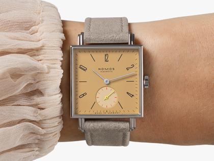 Nomos Glashütte Tetra Origins Ochra Handaufzug Edelstahl 29,5mm gelbes Zifferblatt graues Lederband Glasboden – Damenuhren Uhr ohne Datum aus Edelstahl und Leder. Das Gehäuse ist quadratisch und silber. Das Lederarmband ist grau. Das Zifferblatt ist arabisch Index und gelb. – Ansicht 9