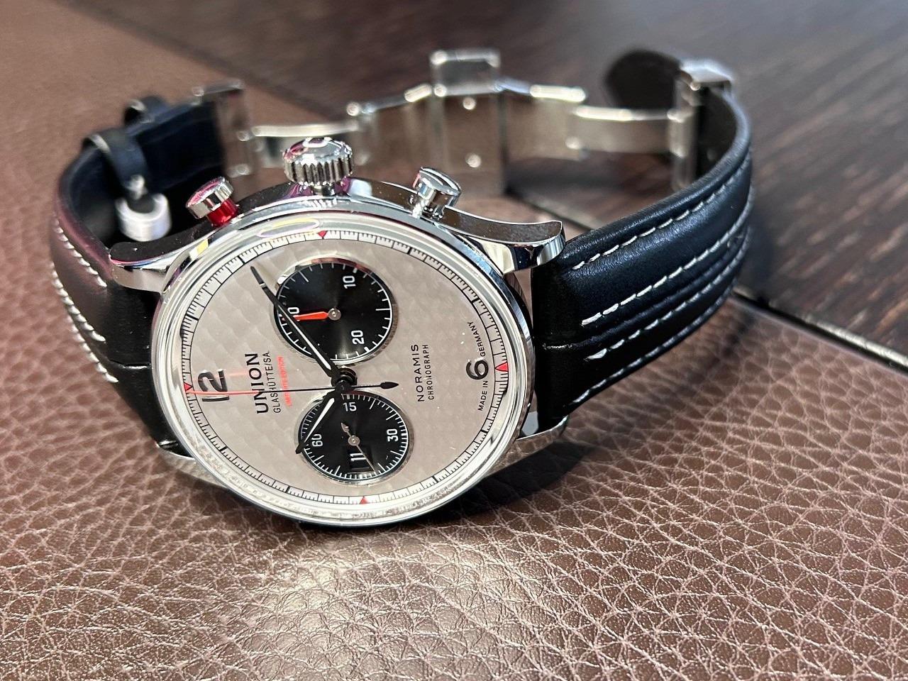 Union Glashütte Noramis Chronograph Sachsen Classic 2025 Limited Edition Automatik Edelstahl 42mm silberfarbenes Zifferblatt schwarzes Lederband – Herrenuhren Chronograph aus Edelstahl und Leder. Das Gehäuse ist rund und silber. Das Lederarmband ist schwarz. Das Zifferblatt ist arabisch Index und silber. – Ansicht 14
