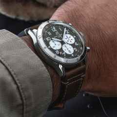 Breitling Super Avi B04 Chronograph GMT 46 Curtiss Warhawk Automatik Edelstahl grünes Zifferblatt braunes Lederband – Herrenuhren Chronograph aus Edelstahl. Das Gehäuse ist rund und silber. Das Lederarmband ist braun. Das Zifferblatt ist arabisch und grün. – Ansicht 5