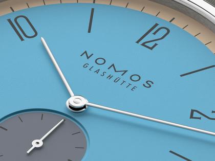 Nomos Glashütte Tangente 38 Datum "175 Years Watchmaking - Delfin" Handaufzug Edelstahl blaues Zifferblatt graues Textilband Glasboden – Herrenuhren Uhr mit Datum aus Edelstahl. Das Gehäuse ist rund und silber. Das Textilarmband ist grau. Das Zifferblatt ist arabisch Index und blau. – Ansicht 5