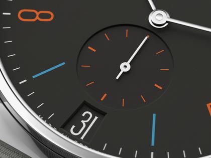 Nomos Glashütte Tangente 38 Datum "175 Years Watchmaking - Dunkelbunt" Handaufzug Edelstahl schwarzes Zifferblatt graues Textilband Glasboden – Herrenuhren Uhr mit Datum aus Edelstahl. Das Gehäuse ist rund und silber. Das Textilarmband ist grau. Das Zifferblatt ist arabisch Index und schwarz. – Ansicht 6