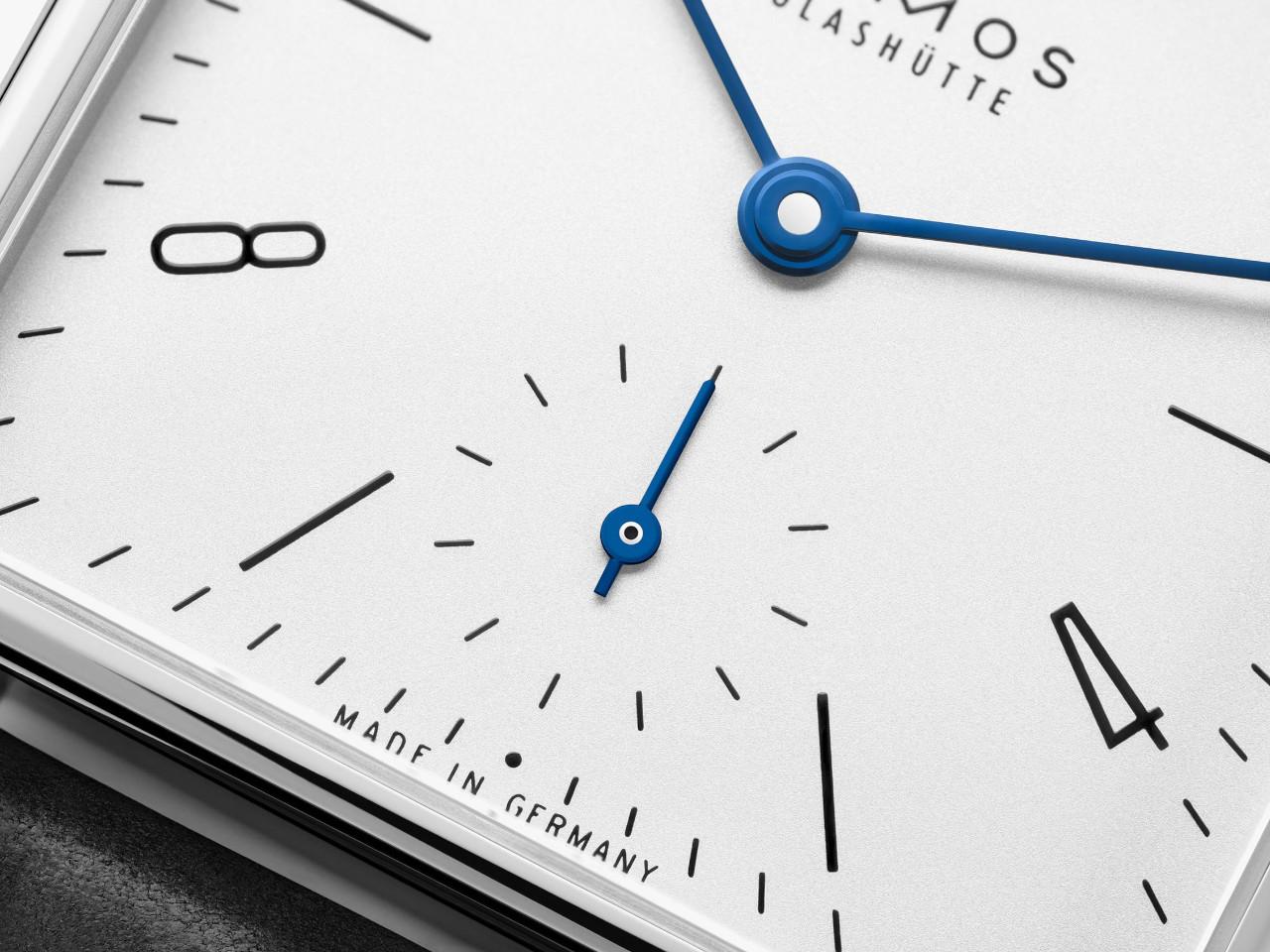 Nomos Glashütte Tetra 27 Weiss Handaufzug Edelstahl 27mm weißes Zifferblatt schwarzes Lederband Glasboden – Damenuhren Uhr ohne Datum aus Edelstahl und Leder. Das Gehäuse ist quadratisch und silber. Das Lederarmband ist schwarz. Das Zifferblatt ist arabisch Index und weiß. – Ansicht 3