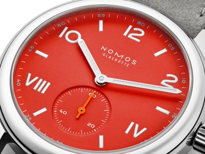 Nomos Glashütte Club Campus Nonstop Red Handaufzug Edelstahl 36mm rotes Zifferblatt graues Lederband Glasboden – Damenuhren Uhr ohne Datum aus Edelstahl und Leder. Das Gehäuse ist rund und silber. Das Lederarmband ist grau. Das Zifferblatt ist arabisch römisch und rot. – Ansicht 2