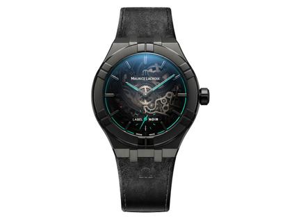 Maurice Lacroix Aikon Manufacture Skeleton Automatik Edelstahl 45mm skelettiertes Zifferblatt graues Lederband und türkises Kautschukband Label Noir limitiert – Herrenuhren Uhr ohne Datum aus Edelstahl, Kautschuk und Leder. Das Gehäuse ist rund und schwarz. Das Lederarmband ist grau. Das Zifferblatt ist skelettiert und grau.