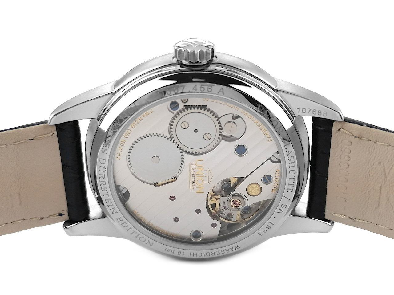 Union Glashütte 1893 Johannes Dürrstein Edition Gangreserve Handaufzug Edelstahl 41mm Lederband D007.456.16.082.00 Full Set mit Garantie Occasion – Herrenuhren Uhr mit Datum aus Edelstahl. Das Gehäuse ist rund und silber. Das Lederarmband ist blau. Das Zifferblatt ist arabisch Index und grau. – Ansicht 2