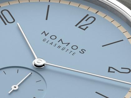 Nomos Glashütte Tangente 38 Datum "175 Years Watchmaking - Frostblau" Handaufzug Edelstahl eisblaues Zifferblatt graues Textilband Glasboden – Herrenuhren Uhr mit Datum aus Edelstahl. Das Gehäuse ist rund und silber. Das Textilarmband ist grau. Das Zifferblatt ist arabisch Index und blau. – Ansicht 4