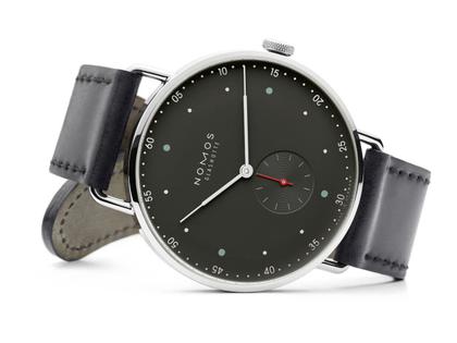 Nomos Glashütte Metro 38 Stadtschwarz Handaufzug Edelstahl 38mm schwarzes Zifferblatt schwarzes Lederband Glasboden – Herrenuhren Uhr ohne Datum aus Edelstahl. Das Gehäuse ist rund und silber. Das Lederarmband ist schwarz. Das Zifferblatt ist arabisch Index und grau. – Ansicht 3