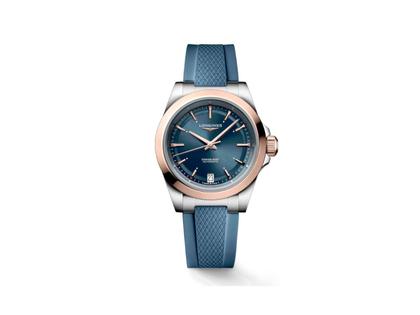 Damenuhren Uhr mit Datum aus 750 Rotgold, Edelstahl und Kautschuk. Das Gehäuse ist rund und silber. Das Kautschuk / Kunststoff / Silikon Armband ist blau. Das Zifferblatt ist ein Index in blau.