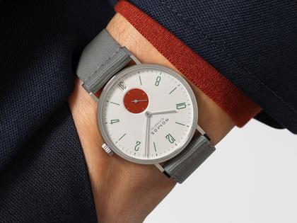 Nomos Glashütte Tangente 38 Datum "175 Years Watchmaking - Stop" Handaufzug Edelstahl cremeweißes Zifferblatt graues Textilband Glasboden – Herrenuhren Uhr mit Datum aus Edelstahl. Das Gehäuse ist rund und silber. Das Textilarmband ist grau. Das Zifferblatt ist arabisch Index und beige. – Ansicht 7