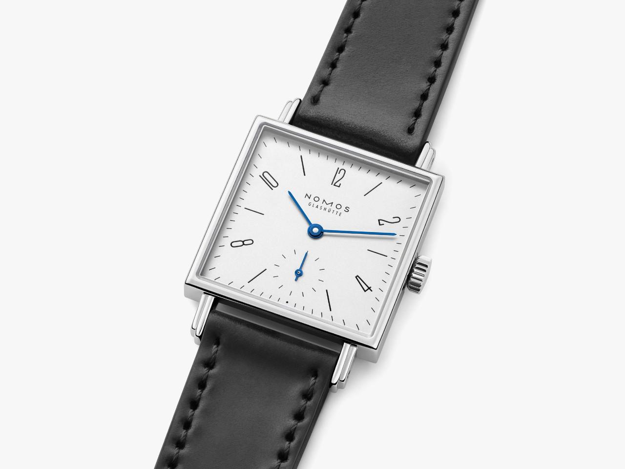 Nomos Glashütte Tetra 27 Weiss Handaufzug Edelstahl 27mm weißes Zifferblatt schwarzes Lederband Stahlboden – Damenuhren Uhr ohne Datum aus Edelstahl und Leder. Das Gehäuse ist quadratisch und silber. Das Lederarmband ist schwarz. Das Zifferblatt ist arabisch Index und weiß. – Ansicht 5