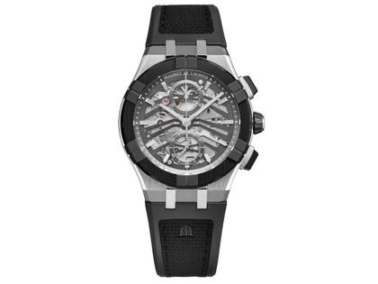 Maurice Lacroix Aikonic Chronograph Automatik Edelstahl 43mm skelettiertes Zifferblatt schwarzes Kautschukband – Herrenuhren Chronograph aus Edelstahl, Kautschuk und Keramik. Das Gehäuse ist rund und silber. Das Kautschuk / Kunststoff / Silikon Armband ist schwarz. Das Zifferblatt ist skelettiert und grau.