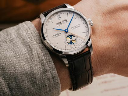 Union Glashütte 1893 Johannes Dürrstein Edition Doppelmondphase Handaufzug Edelstahl 41mm beiges Zifferblatt braunes Lederband – Herrenuhren Uhr mit Datum aus Edelstahl und Leder. Das Gehäuse ist rund und silber. Das Lederarmband ist braun. Das Zifferblatt ist römisch Index und beige. – Ansicht 12