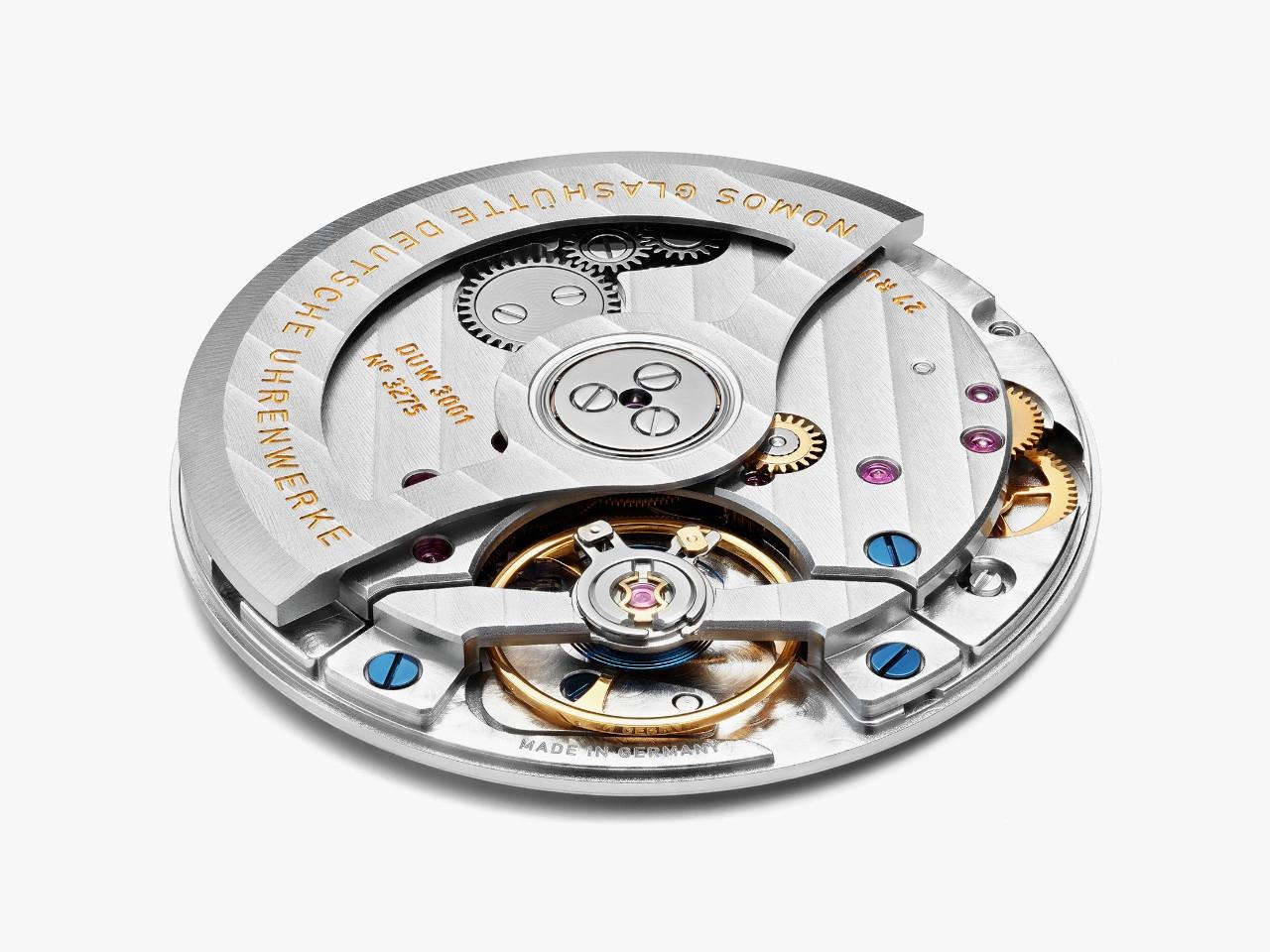 Nomos Glashütte Tangente 39 neomatik Blaugold Automatik Edelstahl 39mm blaues Zifferblatt schwarzes Lederband Glasboden – Herrenuhren Uhr ohne Datum aus Edelstahl. Das Gehäuse ist rund und silber. Das Lederarmband ist schwarz. Das Zifferblatt ist arabisch Index und blau. – Ansicht 4