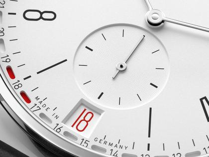 Nomos Glashütte Tangente 2date Handaufzug Edelstahl 38mm weißes Zifferblatt schwarzes Lederband Glasboden – Herrenuhren Uhr mit Datum aus Edelstahl und Leder. Das Gehäuse ist rund und silber. Das Lederarmband ist schwarz. Das Zifferblatt ist arabisch Index und silber. – Ansicht 8