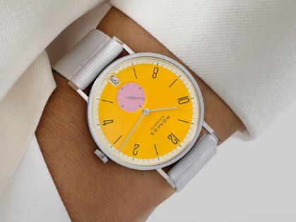 Nomos Glashütte Tangente 38 Datum "175 Years Watchmaking - Katzengold" Handaufzug Edelstahl gelbes Zifferblatt graues Textilband Glasboden – Herrenuhren Uhr mit Datum aus Edelstahl. Das Gehäuse ist rund und silber. Das Textilarmband ist grau. Das Zifferblatt ist arabisch Index und gelb. – Ansicht 7