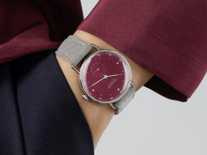 Nomos Glashütte Metro 33 Muted Red Handaufzug Edelstahl 33mm rotes Zifferblatt graues Lederband Stahlboden – Damenuhren Uhr ohne Datum aus Edelstahl und Leder. Das Gehäuse ist rund und silber. Das Lederarmband ist grau. Das Zifferblatt ist ein Index in rot. – Ansicht 4