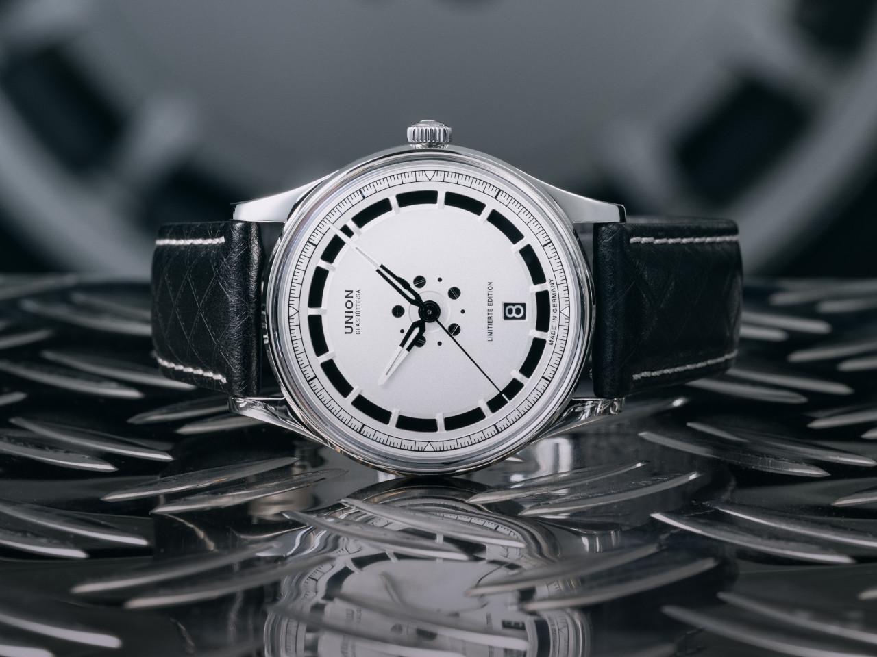 Union Glashütte Noramis Datum Deutschland Klassik 2025 Limitierte Edition Automatik Edelstahl 40mm Felgendesign Zifferblatt schwarzes Lederband – Herrenuhren Uhr mit Datum aus Edelstahl und Leder. Das Gehäuse ist rund und silber. Das Lederarmband ist schwarz. Das Zifferblatt ist ohne Zeichen und schwarz. – Ansicht 6