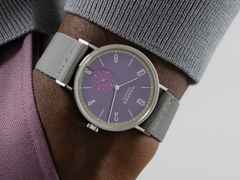Nomos Glashütte Tangente 38 Datum "175 Years Watchmaking - Mauvegrün" Handaufzug Edelstahl violettes Zifferblatt graues Textilband Glasboden – Herrenuhren Uhr mit Datum aus Edelstahl. Das Gehäuse ist rund und silber. Das Textilarmband ist grau. Das Zifferblatt ist arabisch Index und lila. – Ansicht 7
