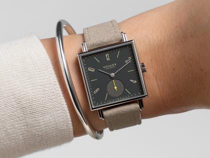 Nomos Glashütte Tetra Origins Basalt Handaufzug Edelstahl 29,5mm schwarzes Zifferblatt graues Lederband Glasboden – Damenuhren Uhr ohne Datum aus Edelstahl und Leder. Das Gehäuse ist quadratisch und silber. Das Lederarmband ist grau. Das Zifferblatt ist arabisch Index und schwarz. – Ansicht 9