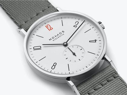 Nomos Glashütte Tangente 38 – 50 ans de Médecins Sans Frontières Limited Edition Handaufzug Edelstahl 38mm weißes Zifferblatt graues Textilband Stahlboden – Herrenuhren Uhr ohne Datum aus Edelstahl und Leder. Das Gehäuse ist rund und silber. Das Textilarmband ist schwarz. Das Zifferblatt ist arabisch Index und weiß. – Ansicht 3