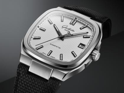 Glashütte Original Seventies Vintage Kollektion Stereo Panel Automatik Edelstahl 39x39mm silbernes Zifferblatt schwarzes Kautschukband – Herrenuhren Uhr mit Datum aus 750 Weißgold, Edelstahl und Kautschuk. Das Gehäuse ist quadratisch und silber. Das Kautschuk / Kunststoff / Silikon Armband ist schwarz. Das Zifferblatt ist ein Index in silber. – Ansicht 3
