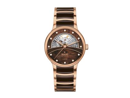 Rado Centrix Diamonds Open Heart Automatik Edelstahl Roségold-PVD 39,5mm braunes Perlmutt-Zifferblatt mit Brillanten Metallband – Damenuhren Uhr ohne Datum aus Edelstahl, Keramik und PVD beschichtet. Das Gehäuse ist rund und roségold. Das Keramikarmband ist braun. Das Zifferblatt ist ein Index in braun.