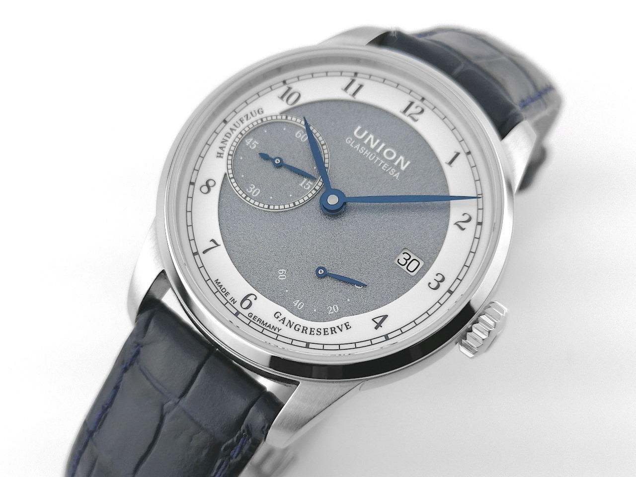 Union Glashütte 1893 Johannes Dürrstein Edition Gangreserve Handaufzug Edelstahl 41mm Lederband D007.456.16.082.00 Full Set mit Garantie Occasion – Herrenuhren Uhr mit Datum aus Edelstahl. Das Gehäuse ist rund und silber. Das Lederarmband ist blau. Das Zifferblatt ist arabisch Index und grau. – Ansicht 3