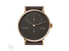 Nomos Glashütte Lambda 39 Samtschwarz Handaufzug Roségold 39mm schwarzes Zifferblatt braunes Lederband – Herrenuhren Uhr ohne Datum aus 750 Rotgold und Leder. Das Gehäuse ist rund und roségold. Das Lederarmband ist braun. Das Zifferblatt ist ein Index in schwarz. – Ansicht 2