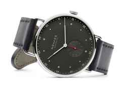 Nomos Glashütte Metro 38 Stadtschwarz Handaufzug Edelstahl 38mm schwarzes Zifferblatt schwarzes Lederband Glasboden – Herrenuhren Uhr ohne Datum aus Edelstahl. Das Gehäuse ist rund und silber. Das Lederarmband ist schwarz. Das Zifferblatt ist arabisch Index und grau. – Ansicht 3
