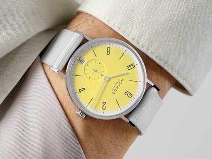 Nomos Glashütte Tangente 38 Datum "175 Years Watchmaking - Kanari" Handaufzug Edelstahl gelbes Zifferblatt graues Textilband Glasboden – Herrenuhren Uhr mit Datum aus Edelstahl. Das Gehäuse ist rund und silber. Das Textilarmband ist grau. Das Zifferblatt ist arabisch Index und gelb. – Ansicht 6