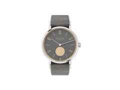 Nomos Glashütte Tangente 38 Datum "175 Years Watchmaking - Haifischgrau" Handaufzug Edelstahl graues Zifferblatt graues Textilband Glasboden – Herrenuhren Uhr mit Datum aus Edelstahl. Das Gehäuse ist rund und silber. Das Textilarmband ist grau. Das Zifferblatt ist arabisch Index und grau.