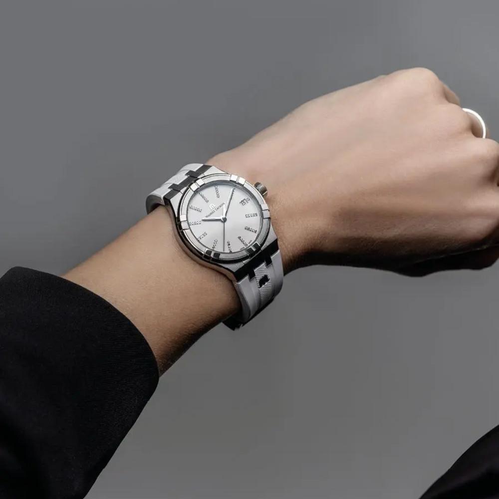 Maurice Lacroix Aikon Quartz Edelstahl 35mm weißes Zifferblatt weißes Kautschukband – Damenuhren Uhr mit Datum aus Edelstahl, Kautschuk, PVD beschichtet und vergoldet. Das Gehäuse ist rund und silber. Das Kautschuk / Kunststoff / Silikon Armband ist weiß. Das Zifferblatt ist ein Index in weiß. – Ansicht 3