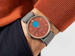 Nomos Glashütte Tangente 38 Datum "175 Years Watchmaking - Ziegelblau" Handaufzug Edelstahl rotes Zifferblatt graues Textilband Glasboden – Herrenuhren Uhr mit Datum aus Edelstahl. Das Gehäuse ist rund und silber. Das Textilarmband ist grau. Das Zifferblatt ist arabisch Index und rot. – Ansicht 7