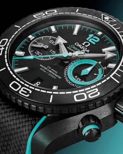 Omega Seamaster Planet Ocean 600M Chronograph ETNZ Deep Black Automatik Keramik 45,5mm schwarzes Zifferblatt schwarz türkises Kautschukband – Herrenuhren Chronograph aus Edelstahl, Kautschuk und Keramik. Das Gehäuse ist rund und schwarz. Das Kautschuk / Kunststoff / Silikon Armband ist schwarz. Das Zifferblatt ist arabisch Index und schwarz. – Ansicht 3