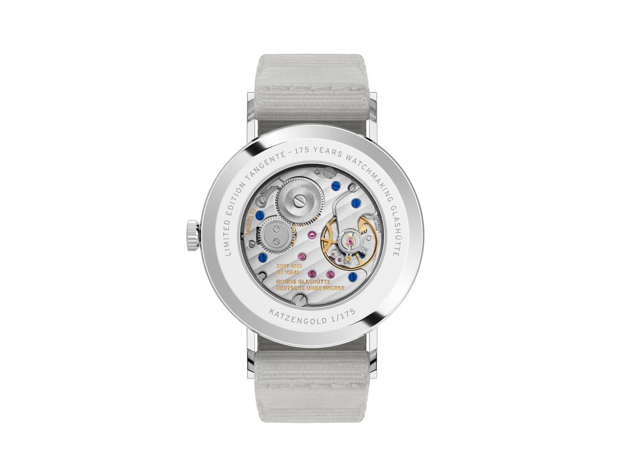 Nomos Glashütte Tangente 38 Datum "175 Years Watchmaking - Katzengold" Handaufzug Edelstahl gelbes Zifferblatt graues Textilband Glasboden – Herrenuhren Uhr mit Datum aus Edelstahl. Das Gehäuse ist rund und silber. Das Textilarmband ist grau. Das Zifferblatt ist arabisch Index und gelb. – Ansicht 2