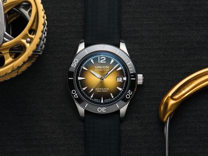 Union Glashütte Noramis Datum Sport Automatik Edelstahl 42mm gelb-schwarzes Zifferblatt schwarzes Textilband – Herrenuhren Uhr mit Datum aus Edelstahl und Keramik. Das Gehäuse ist rund und silber. Das Kautschuk / Kunststoff / Silikon Armband ist schwarz. Das Zifferblatt ist arabisch Index und gelb. – Ansicht 2