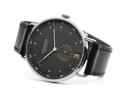 Nomos Glashütte Metro 38 Datum Stadtschwarz Handaufzug Edelstahl 38mm schwarzes Zifferblatt schwarzes Lederband – Herrenuhren Uhr mit Datum aus Edelstahl. Das Gehäuse ist rund und silber. Das Lederarmband ist schwarz. Das Zifferblatt ist arabisch Index und grau. – Ansicht 3