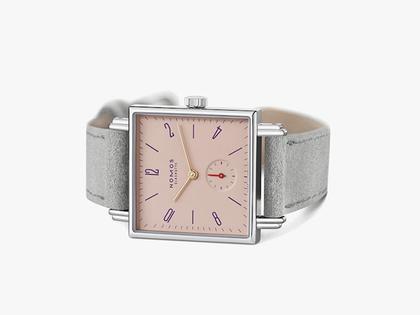 Nomos Glashütte Tetra Petit Four Perle Handaufzug Edelstahl 29mm rosafarbenes Zifferblatt graues Lederband Glasboden – Damenuhren Uhr ohne Datum aus Edelstahl. Das Gehäuse ist quadratisch und silber. Das Lederarmband ist grau. Das Zifferblatt ist arabisch Index und rosa. – Ansicht 3