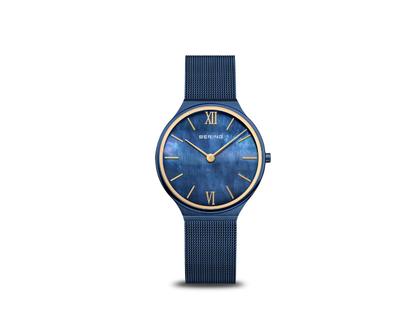 Bering Ultra Slim Quarz Edelstahl 34mm blaues Zifferblatt blaues Metallband – Damenuhren Uhr ohne Datum aus Edelstahl. Das Gehäuse ist rund und blau. Das Edelstahlarmband ist blau. Das Zifferblatt ist römisch Index und blau.