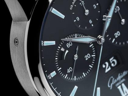 Glashütte Original Senator Chronograph Panoramadatum Automatik Edelstahl 42mm schwarzes Zifferblatt schwarzes Kautschukband – Herrenuhren Chronograph aus Edelstahl. Das Gehäuse ist rund und silber. Das Kautschuk / Kunststoff / Silikon Armband ist schwarz. Das Zifferblatt ist römisch Index und schwarz. – Ansicht 2