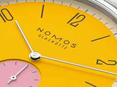 Nomos Glashütte Tangente 38 Datum "175 Years Watchmaking - Katzengold" Handaufzug Edelstahl gelbes Zifferblatt graues Textilband Glasboden – Herrenuhren Uhr mit Datum aus Edelstahl. Das Gehäuse ist rund und silber. Das Textilarmband ist grau. Das Zifferblatt ist arabisch Index und gelb. – Ansicht 6