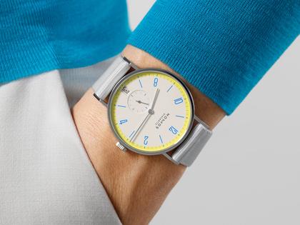 Nomos Glashütte Tangente 38 Datum "175 Years Watchmaking - Lemonbiscuit" Handaufzug Edelstahl cremeweißes Zifferblatt graues Textilband Glasboden – Herrenuhren Uhr mit Datum aus Edelstahl. Das Gehäuse ist rund und silber. Das Textilarmband ist grau. Das Zifferblatt ist arabisch Index und beige. – Ansicht 7