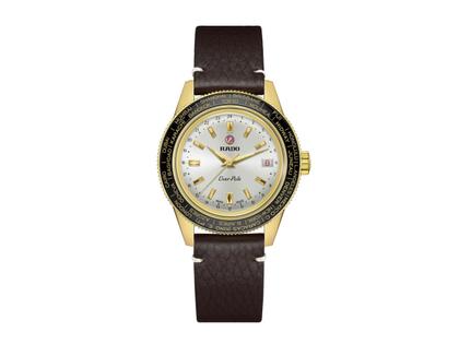 Rado Captain Cook Over-Pole Handaufzug Edelstahl Gelbgold-PVD 39mm silberfarbenes Zifferblatt braunes Lederband Limited Edition – Herrenuhren Uhr mit Datum aus Edelstahl, Keramik, Leder und PVD beschichtet. Das Gehäuse ist rund und gelbgold. Das Lederarmband ist braun. Das Zifferblatt ist ein Index in silber.