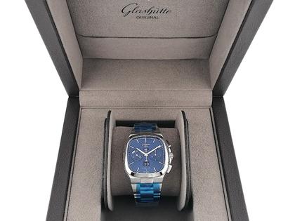 Glashütte Original Seventies Chronograph Panoramadatum Automatik Edelstahl 40mm blau Metallband 1-37-02-08-02-70 Full Set Occasion Neu – Herrenuhren Chronograph aus Edelstahl. Das Gehäuse ist quadratisch und silber. Das Edelstahlarmband ist silber. Das Zifferblatt ist ein Index in blau. – Ansicht 5